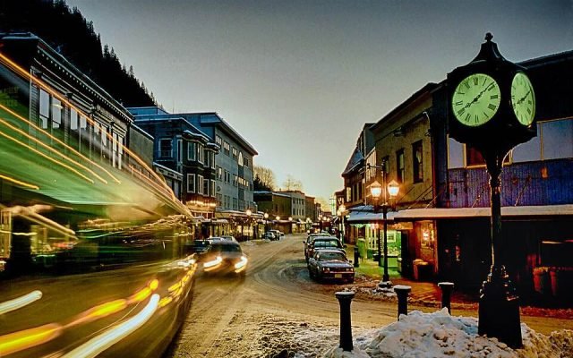 Franklin Street in downtown Juneau at dusk, with old storefronts and a street clock
