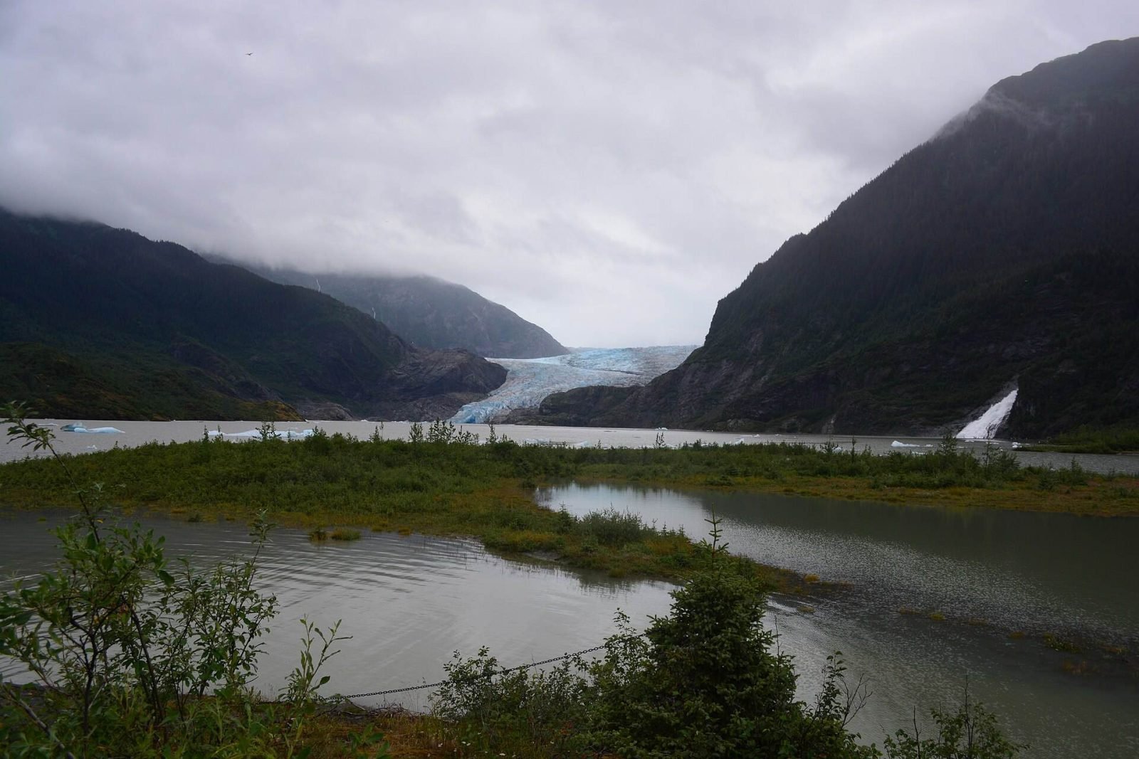 Mendenhall Glacier at the head of the lake, seen across green wetland from Photo Point